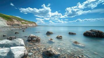 Ocean waves crashing on rocks with dramatic sky and cliffs in background photo