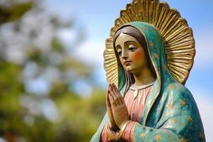 Statue of our lady of guadalupe praying in front of blurred background photo