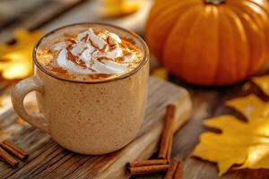Pumpkin spice latte decorated with whipped cream and cinnamon sitting on rustic table with autumn leaves and pumpkin photo