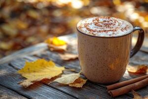 Pumpkin spice latte sitting on table with autumn leaves and cinnamon sticks photo