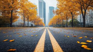 A serene autumn scene features an empty road covered in vibrant fallen leaves, with impressive city buildings rising majestically in the background, showcasing the essence of urban beauty photo