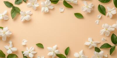 The flat lay features fragrant jasmine flowers and lush green leaves against a soft beige backdrop, creating a calming atmosphere that embodies serene beauty for artistic endeavors photo