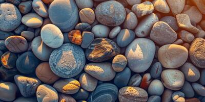 The beach is decorated with multicolored pebbles, basking in the warm sunset light, creating a soothing atmosphere photo