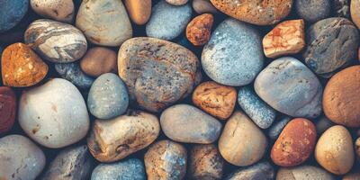 Closeup of river rocks, displaying diverse natural colors and textures, creating a beautiful and serene display photo