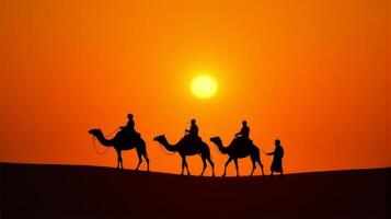 Silhouette of Camel Riders Against an Orange Hued Sky on a Desert Dunes Under Dramatic Sunset photo