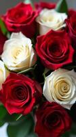 Dense Bouquet Featuring a Vibrant Contrast of Red and White Roses, With Lush Green Leaves Peeking Through the Petals photo