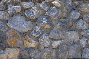 Grey stone wall with different sized stones, modern siding photo