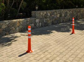 Sidewalk anti-parking bollards with reflective tape in the parking lot 13 photo