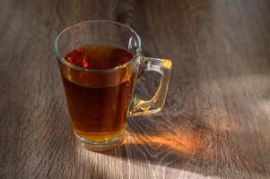 tea in glass cup on wooden table with bright, relaxing tea time concept photo