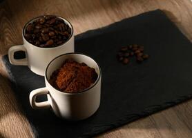 Variety of cups of coffee and coffee beans on old wooden table photo