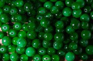 green balls of real stone for making amulets as a background 2 photo
