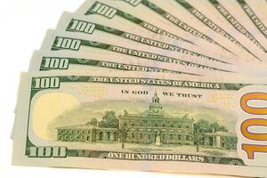 Hundred dollar bills of a new sample lie in a fan shaped photo