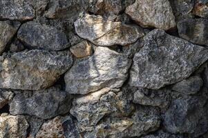 sun rays on a wall made of real stone close-up texture photo