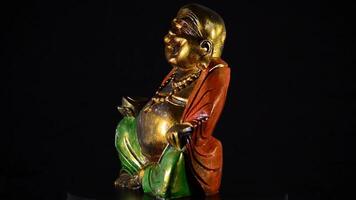 Buddha smiling and fat rotating at black background video