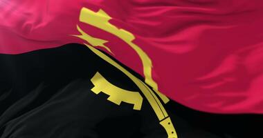 Angolan flag waving at wind in slow with blue sky, loop video