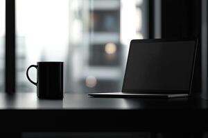 Laptop and coffee cup on black table in office. Workplace concept photo