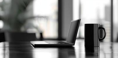 Laptop and coffee cup on black table in office. Workplace concept photo