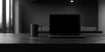 Laptop and coffee cup on black table in office. Workplace concept photo