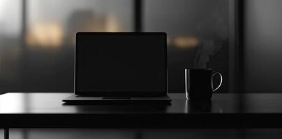 Laptop and coffee cup on black table in office. Workplace concept photo