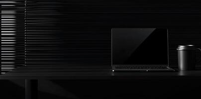 Laptop and coffee cup on black table in office. Workplace concept photo