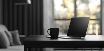 Laptop and coffee cup on black table in office. Workplace concept photo