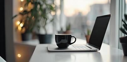 Blurred background of a modern home office interior with a laptop computer and a coffee cup on a white table, with copy space for text in the blurred window view. Business work from home concep photo