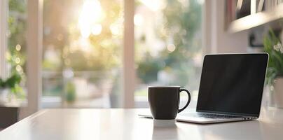 Blurred background of a modern home office interior with a laptop computer and a coffee cup on a white table, with copy space for text in the blurred window view. Business work from home concep photo