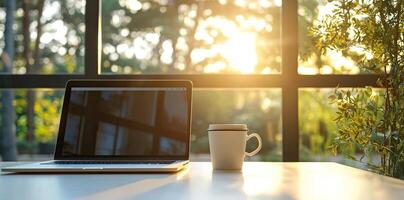 Blurred background of a modern home office interior with a laptop computer and a coffee cup on a white table, with copy space for text in the blurred window view. Business work from home concep photo