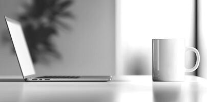 Minimalist white office desk with laptop and coffee mug on a blurred background, with space for text, representing the concept of working from home photo