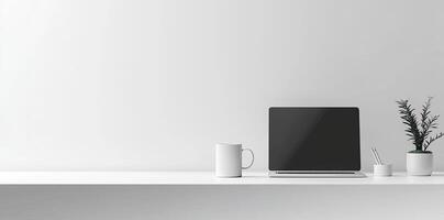 Minimalist white office desk with laptop and coffee mug on a blurred background, with space for text, representing the concept of working from home photo