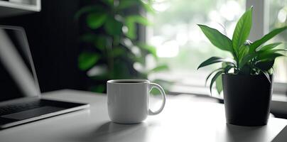 Minimalist white office desk with laptop and coffee mug on a blurred background, with space for text, representing the concept of working from home photo