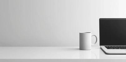 Minimalist white office desk with laptop and coffee mug on a blurred background, with space for text, representing the concept of working from home photo