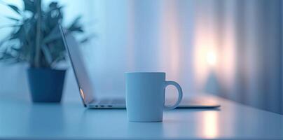 Minimalist white office desk with laptop and coffee mug on a blurred background, with space for text, representing the concept of working from home photo