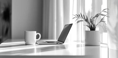 Minimalist white office desk with laptop and coffee mug on a blurred background, with space for text, representing the concept of working from home photo