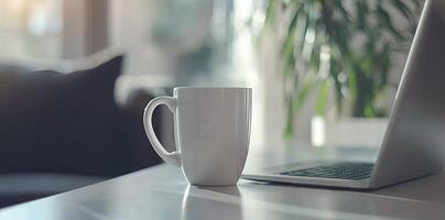 Minimalist white office desk with laptop and coffee mug on a blurred background, with space for text, representing the concept of working from home photo