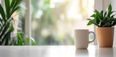 Minimalist white office desk with laptop and coffee mug on a blurred background, with space for text, representing the concept of working from home photo