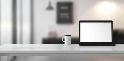 Minimalist white office desk with laptop and coffee mug on a blurred background, with space for text, representing the concept of working from home photo