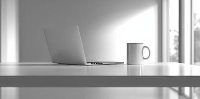 Minimalist white office desk with laptop and coffee mug on a blurred background, with space for text, representing the concept of working from home photo