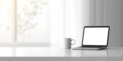 Minimalist white office desk with laptop and coffee mug on a blurred background, with space for text, representing the concept of working from home photo
