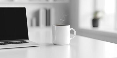 Minimalist white office desk with laptop and coffee mug on a blurred background, with space for text, representing the concept of working from home photo