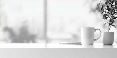 Minimalist white office desk with laptop and coffee mug on a blurred background, with space for text, representing the concept of working from home photo