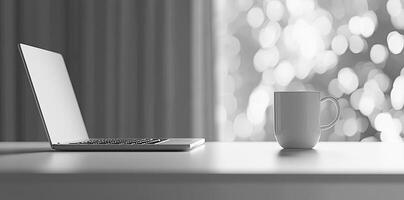 Minimalist white office desk with laptop and coffee mug on a blurred background, with space for text, representing the concept of working from home photo