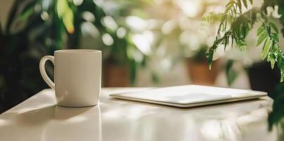 Minimalist white office desk with laptop and coffee mug on a blurred background, with space for text, representing the concept of working from home photo