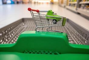 Conceptual Image of Green Car in Shopping Cart Symbolizing Auto Purchase and Consumerism photo