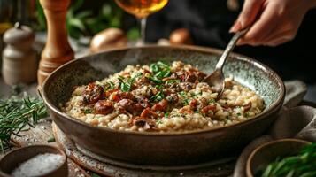 The chef prepares Risotto with mushrooms. Risotto with mushrooms is served in an elegant plate photo