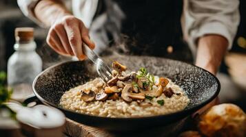 The chef prepares Risotto with mushrooms. Risotto with mushrooms is served in an elegant plate photo