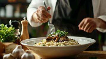The chef prepares Risotto with mushrooms. Risotto with mushrooms is served in an elegant plate photo
