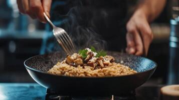 The chef prepares Risotto with mushrooms. Risotto with mushrooms is served in an elegant plate photo