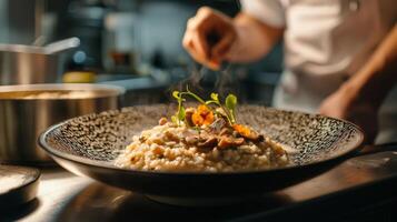 The chef prepares Risotto with mushrooms. Risotto with mushrooms is served in an elegant plate photo