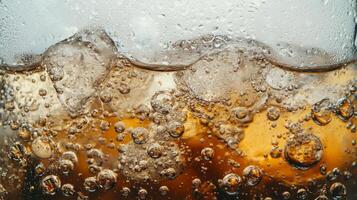 A glass of soda with ice cubes in it. The bubbles in the soda are rising to the top photo